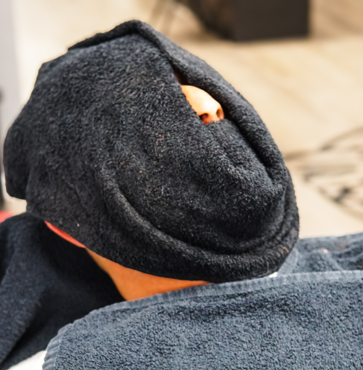 Man with hot towel covering face