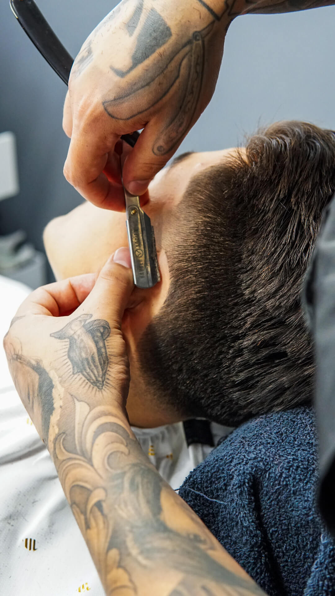 barber shaving using straight razor